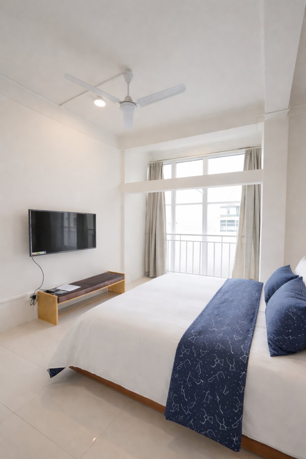 Signature Room — spacious bedroom with TV and balcony view